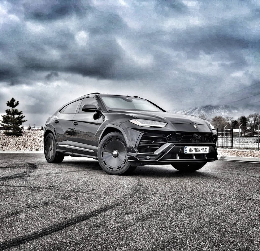 Armormax armored Lamborghini Urus bulletproof luxury SUV driving on road in Utah with mountain backdrop.