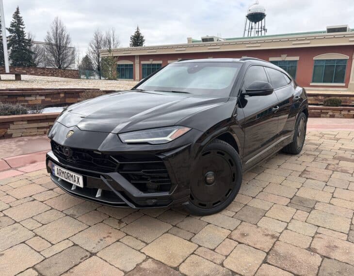 Armormax armored Lamborghini Urus bulletproof luxury SUV driving on road in Utah with mountain backdrop.