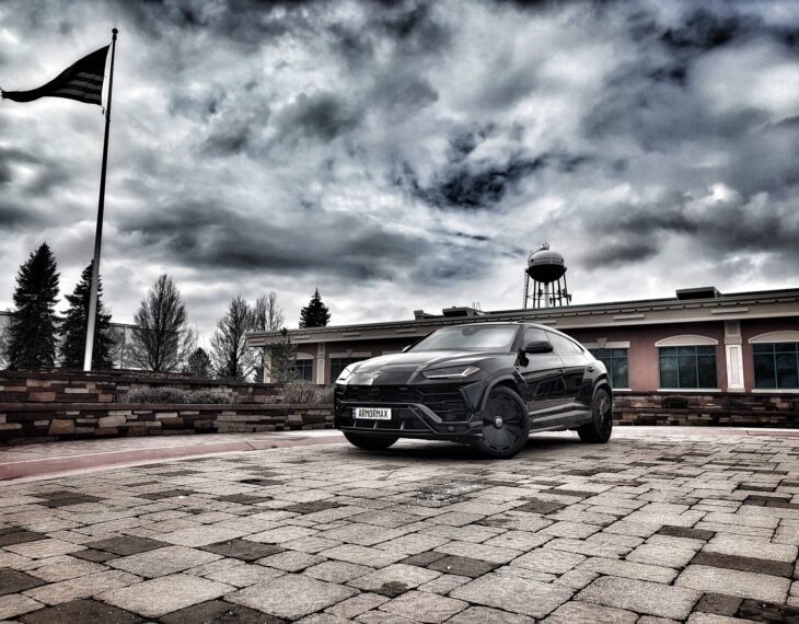 Armormax armored Lamborghini Urus bulletproof luxury SUV driving on road in Utah with mountain backdrop.