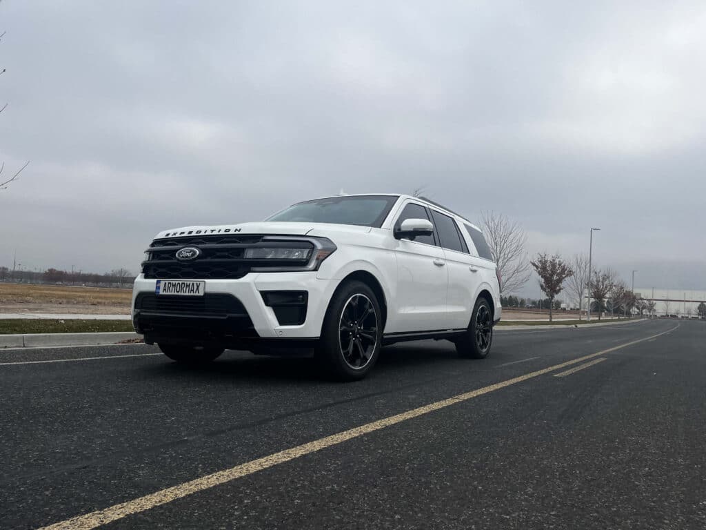 Driving White Armored Ford Expedition SUV Luxury SUV with integrated ballistic protection system by Armormax.